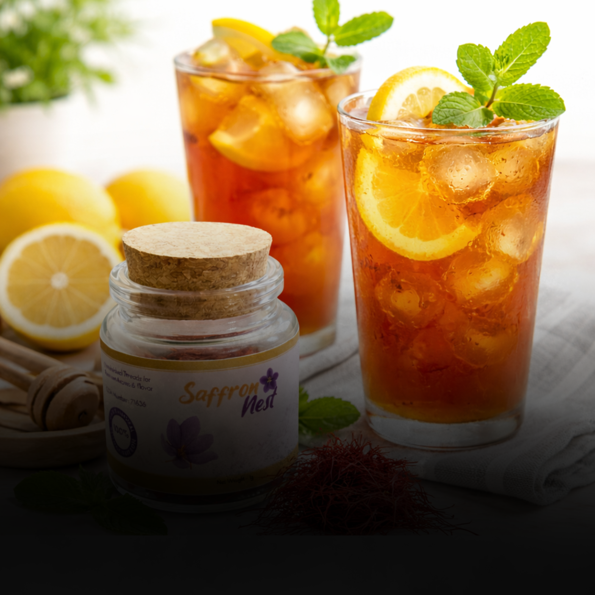 Two glasses of iced tea with lemon slices and a jar labeled 'Saffron' on a light surface.